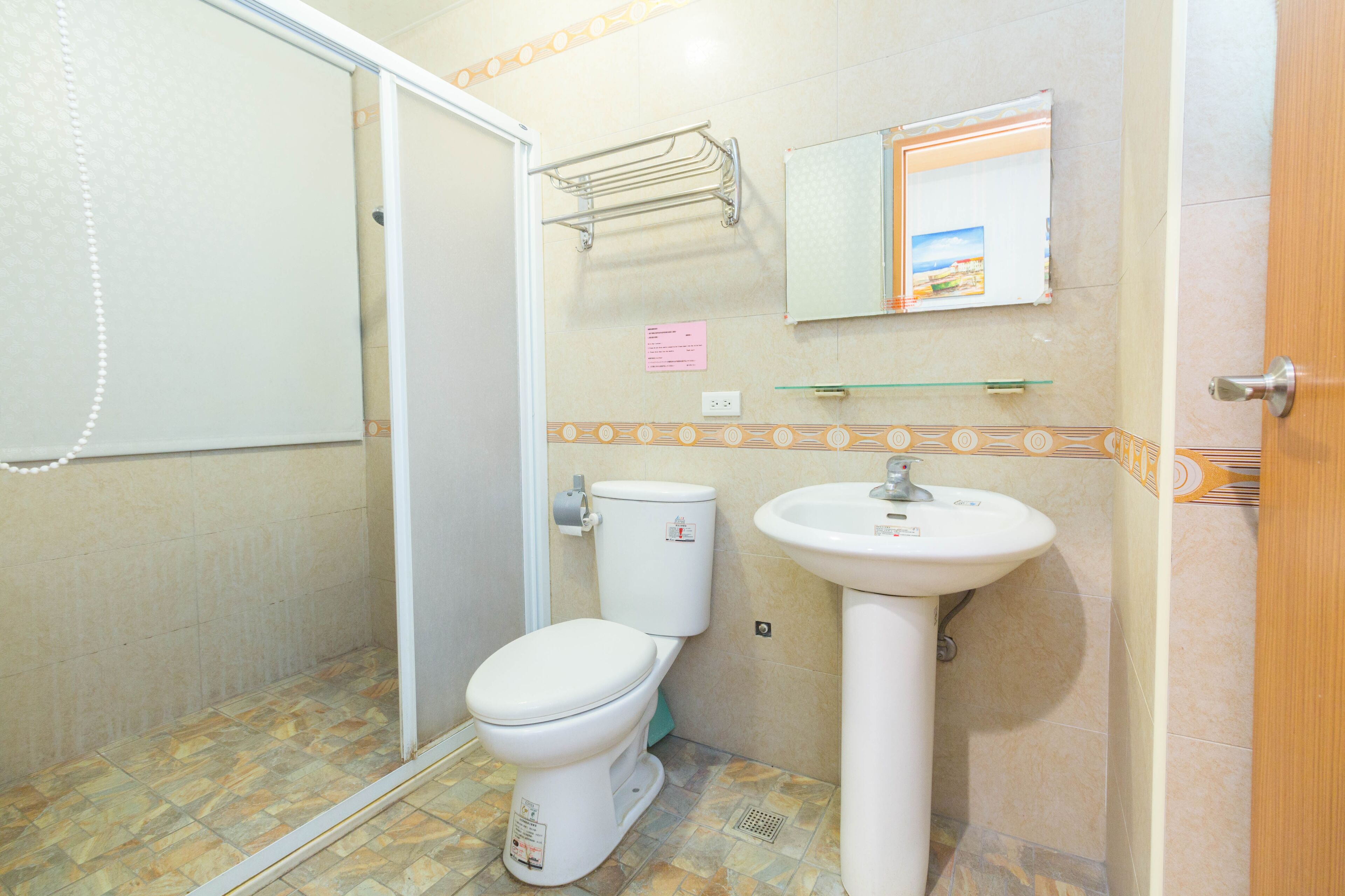 A bathroom with a toilet, sink, and shower.