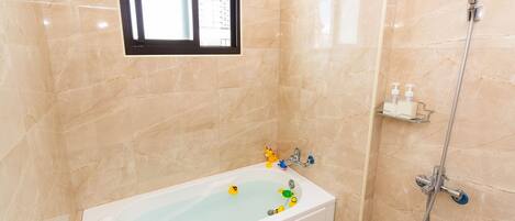 Un baño con bañera, ducha y ventana.