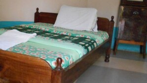 A single bed with a floral bedspread and a white pillow.