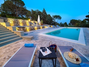 Una piscina al aire libre de temporada, sillones reclinables de piscina