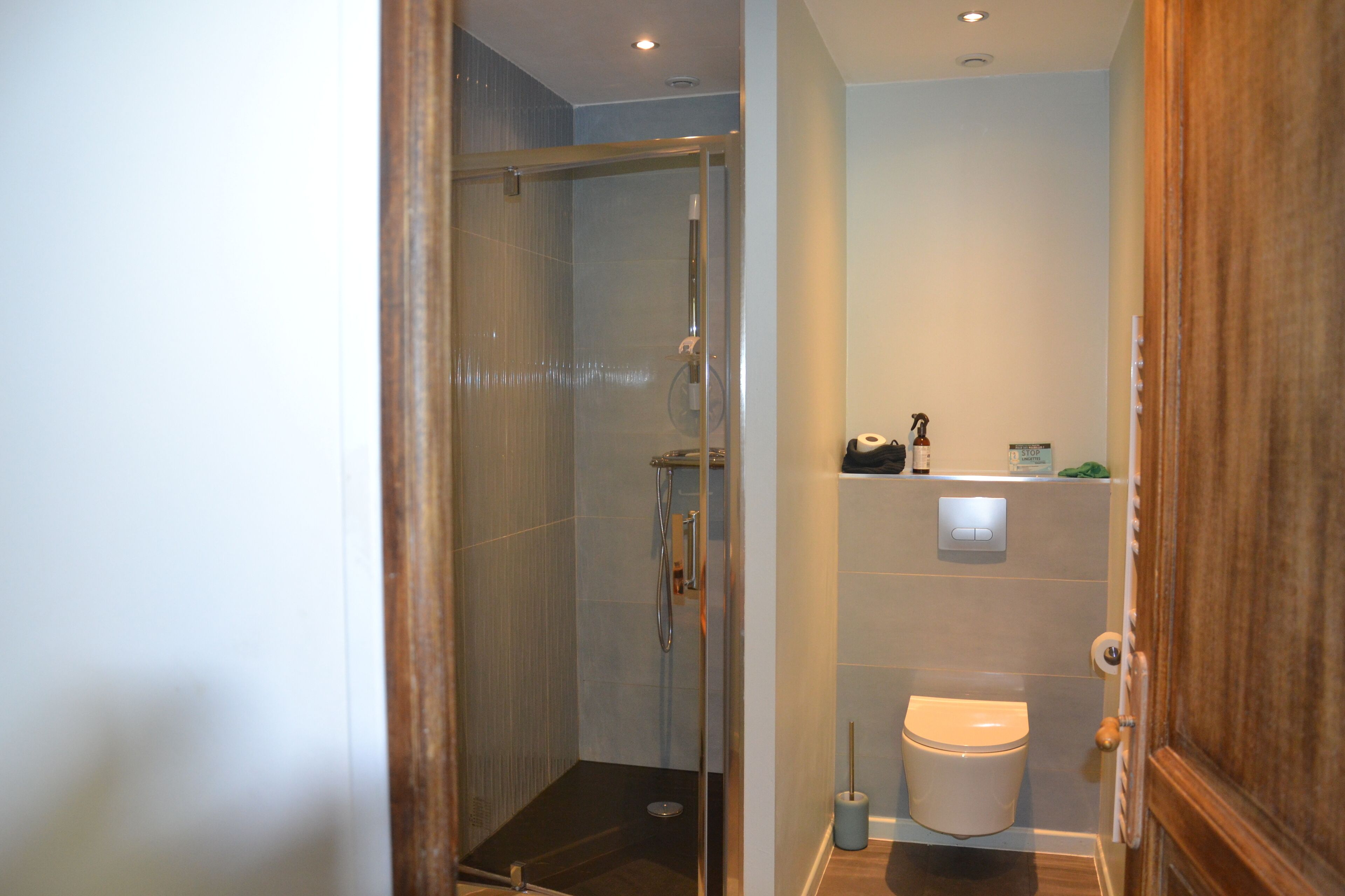 Une salle de bain avec une douche à parois de verre, des toilettes et un lavabo avec un miroir.