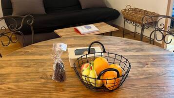 Une table à manger avec un panier de fruits, une boîte et un sac de collations.
