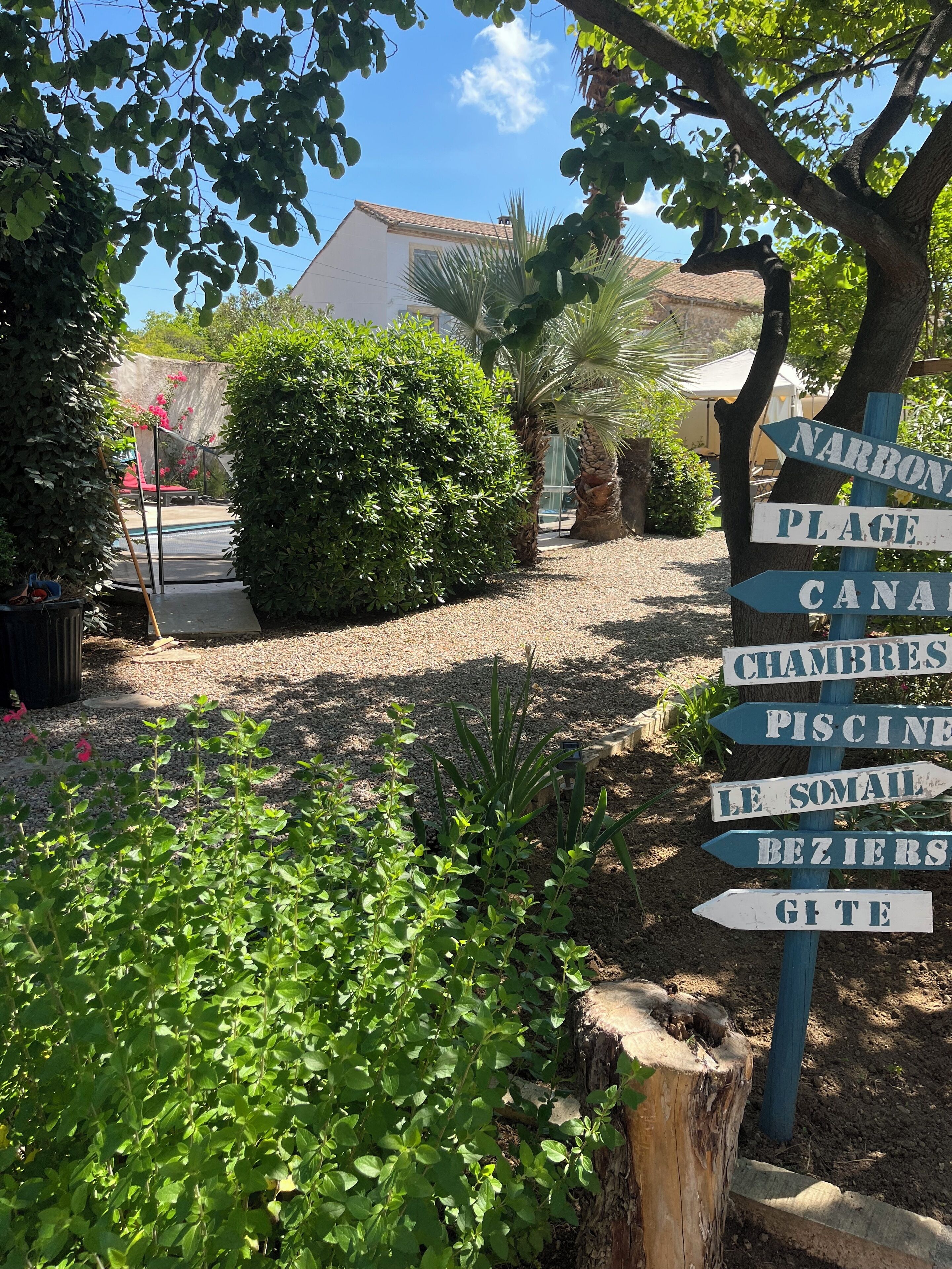 Un cartel con indicaciones hacia varios servicios, como una playa, piscina y restaurante.