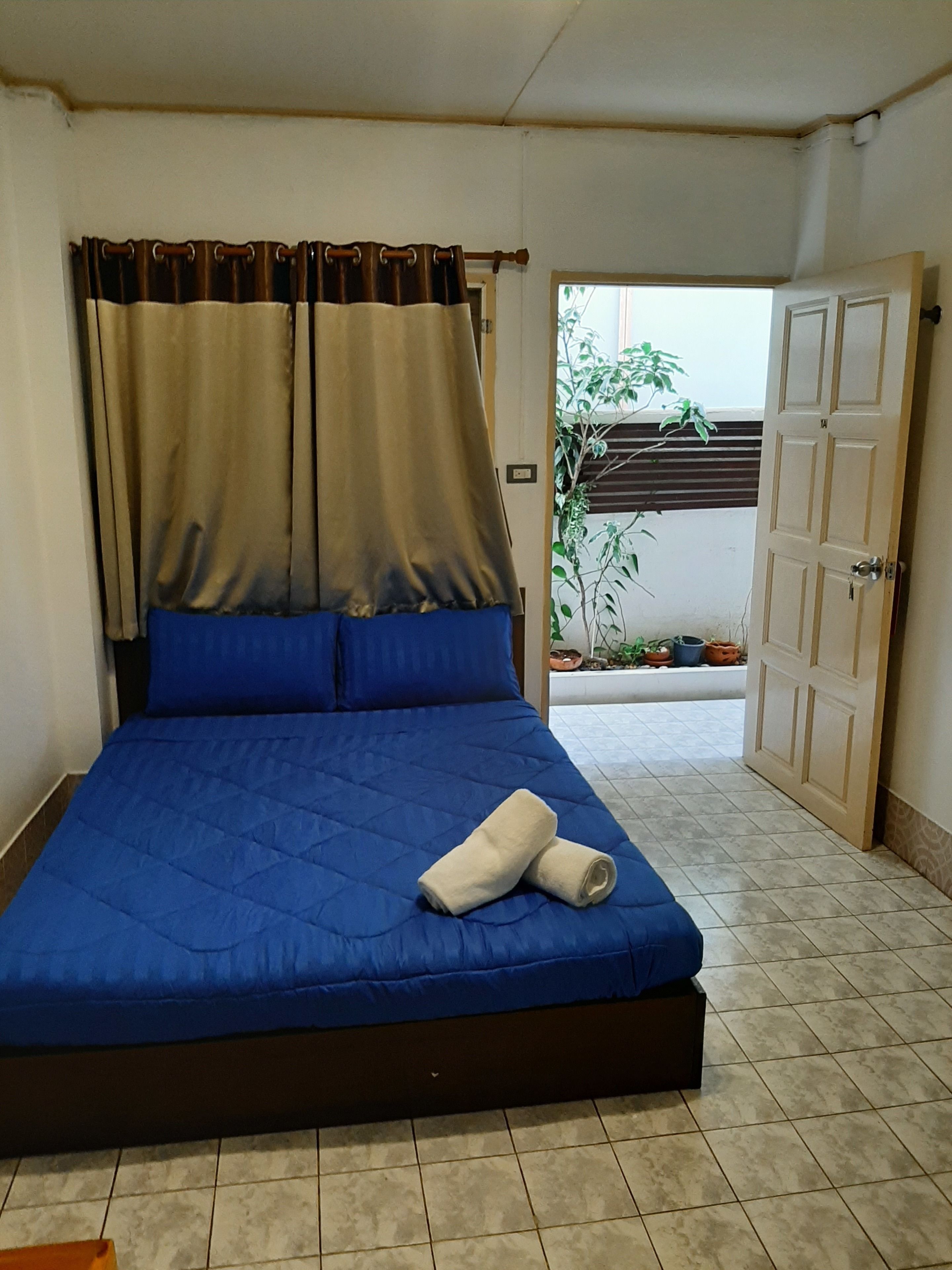 A bedroom with a bed, curtains, and a door.