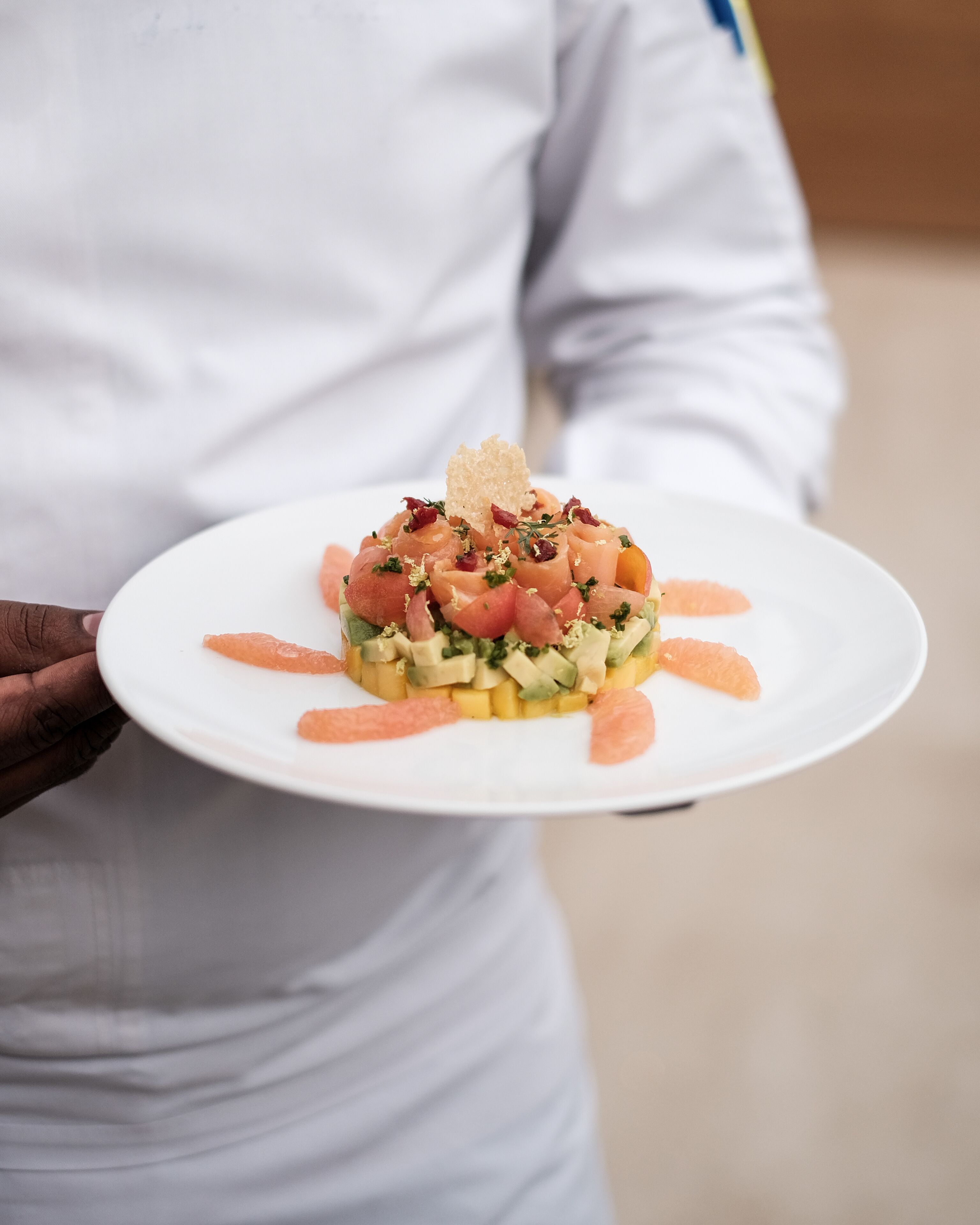 Una persona sosteniendo un plato blanco con un plato de mariscos.