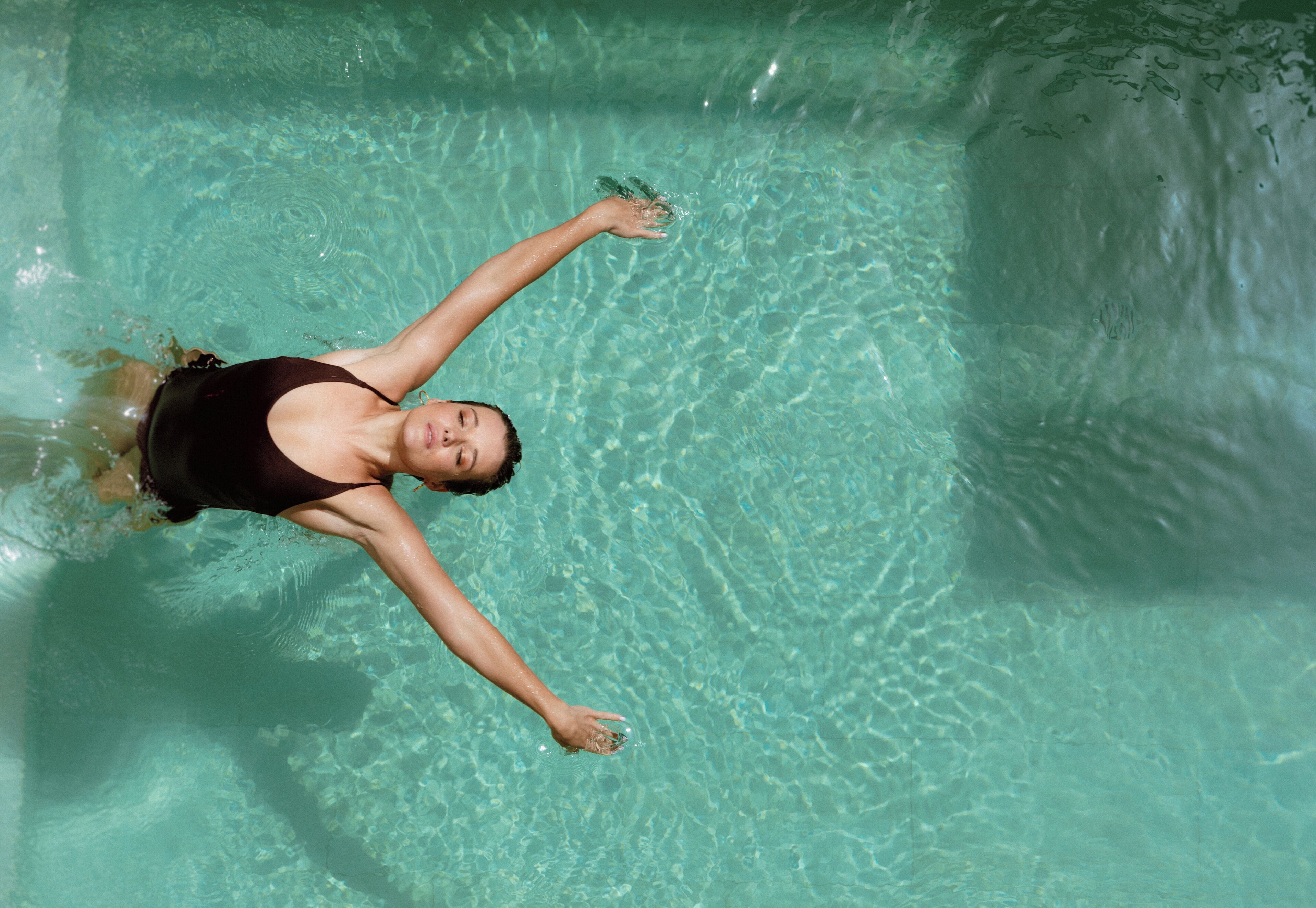 Una persona nadando en una piscina cristalina.