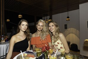 Three people seated at a table with various dishes and drinks. - La Brillante (Marrakech)