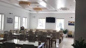 A spacious conference room with high ceilings, chandeliers, and a large screen. - The Marine Hotel (Bai Chay)