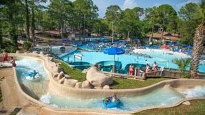 Een waterpark met meerdere zwembaden, glijbanen en een golfslagbad.