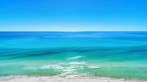 Een strand met helder turquoise water en een zandstrand.