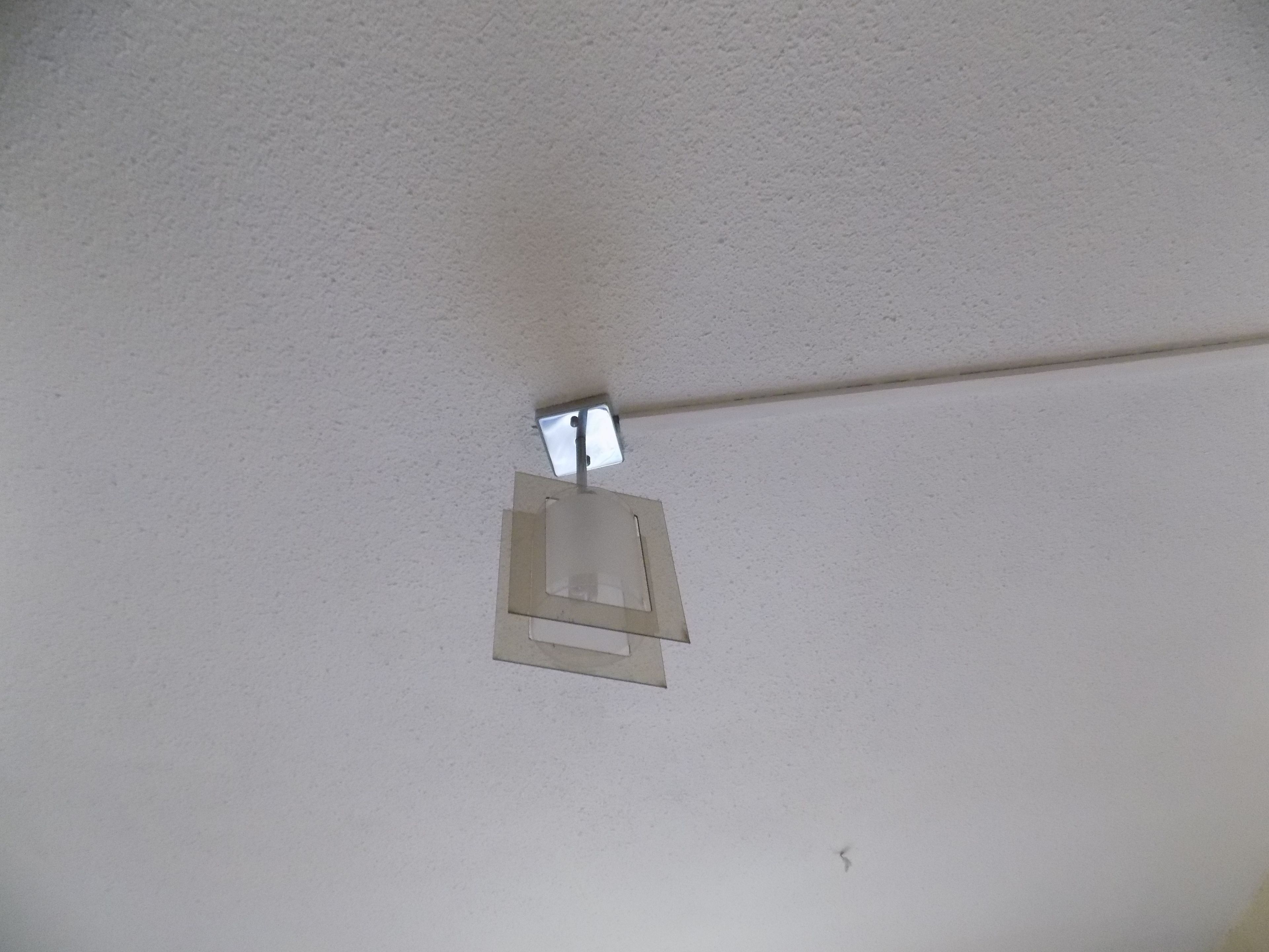 A ceiling with a light fixture and a small window.