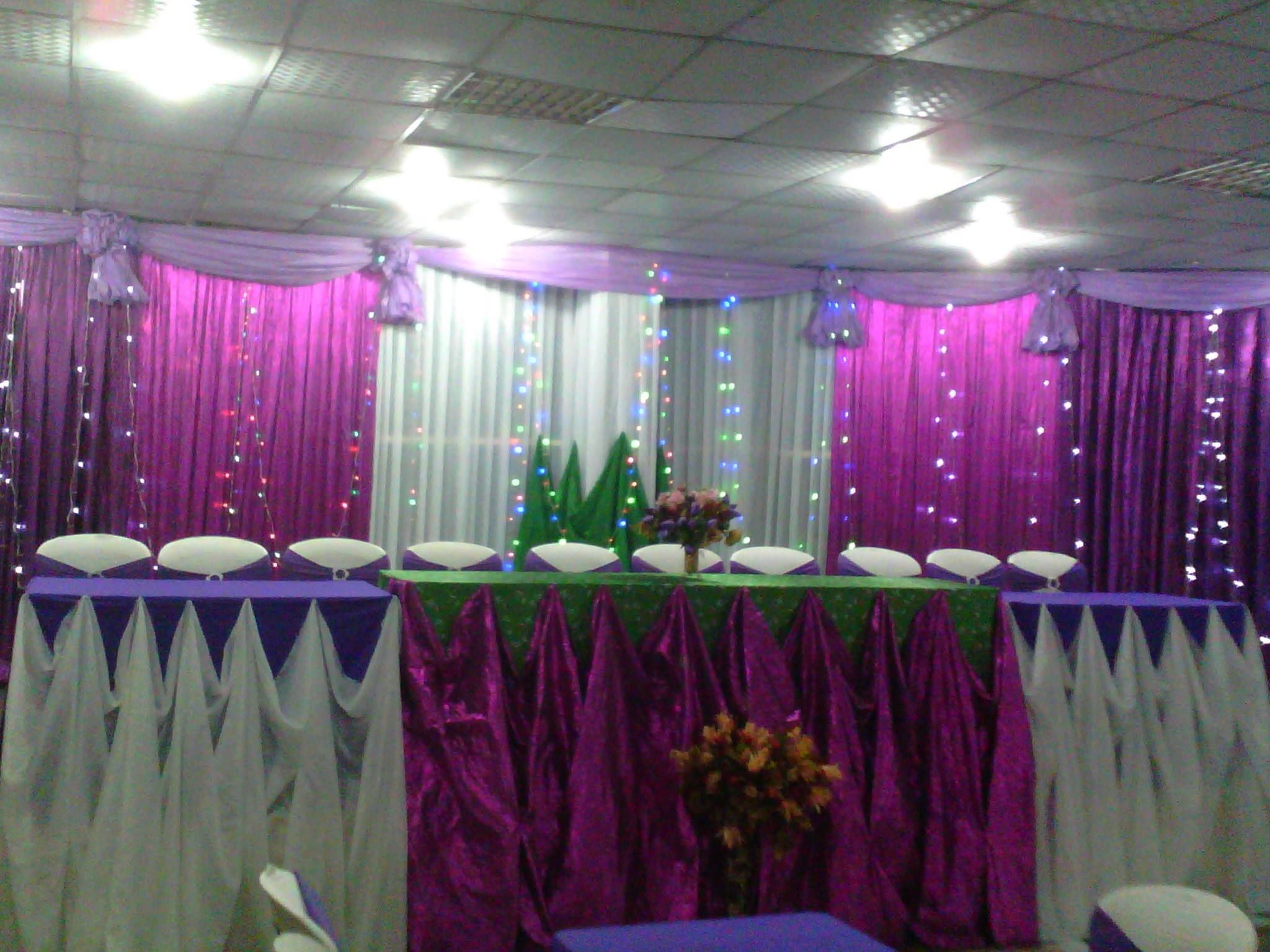 A conference room with a long table, chairs, and draped curtains.