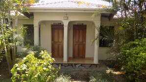 A building with two wooden doors labeled "Room 1" and "Room 2". - Cielo Country Inn (Ishaka)