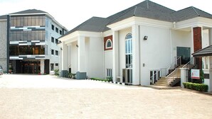 A modern building with a large entrance, a covered area, and a staircase leading to the upper floors.