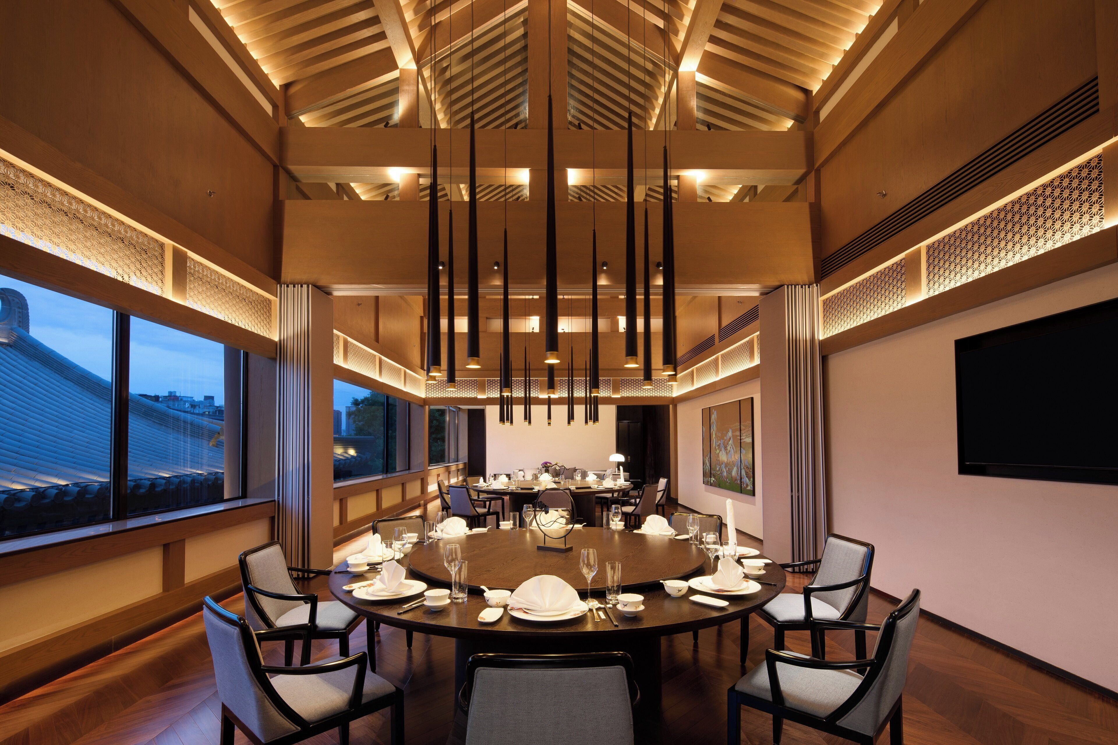 A conference room with a round table, chairs, and a large window.