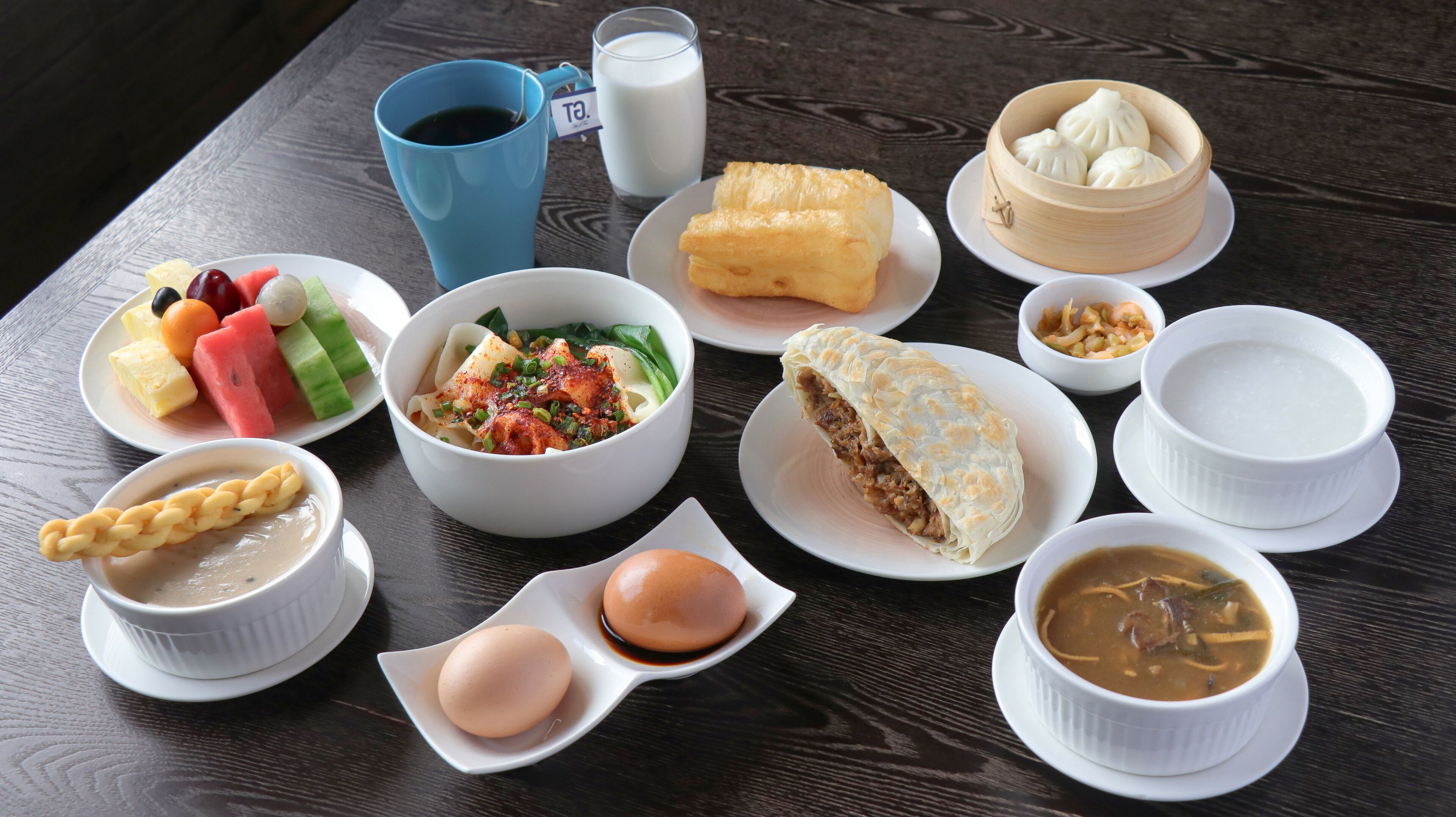 Diverse gerechten, waaronder dumplings, een kom soep en een bord groenten.