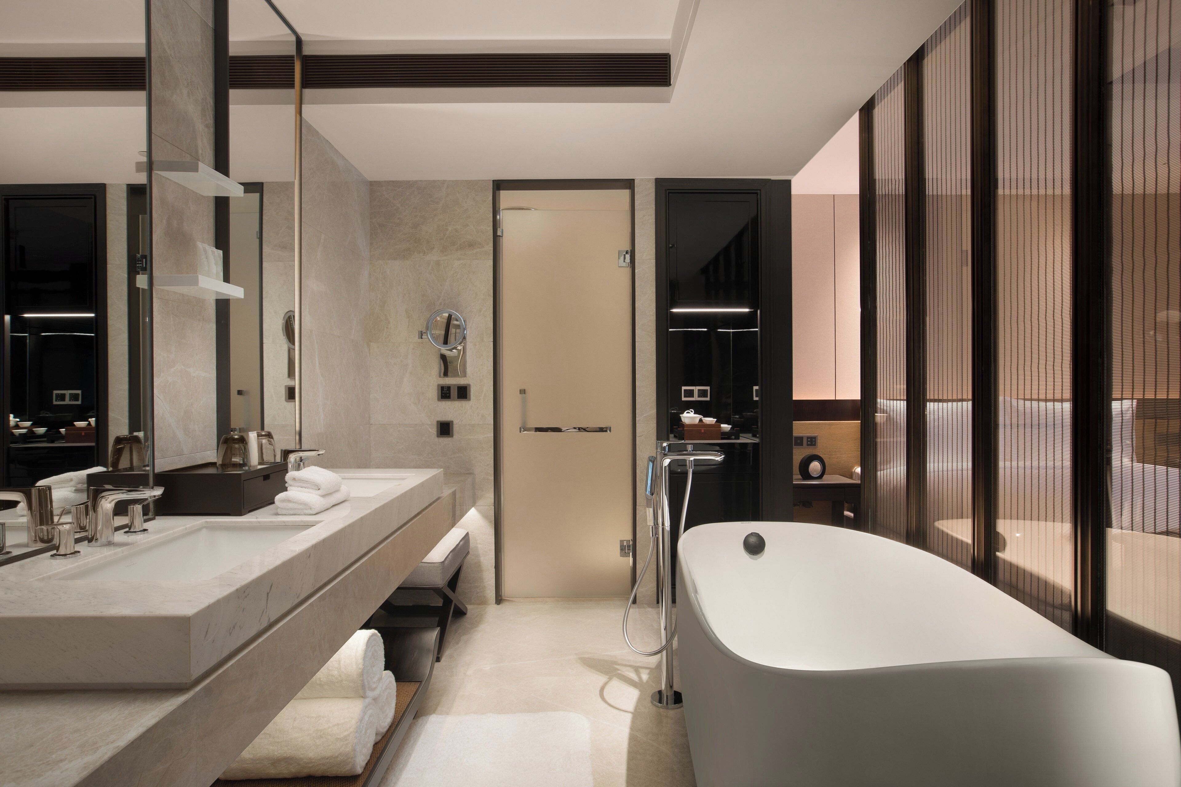 Un baño moderno con una bañera grande, un tocador con espejo y una zona de ducha.