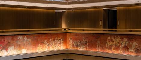 A spacious lobby with a high ceiling, a central seating area, and a decorative wall.