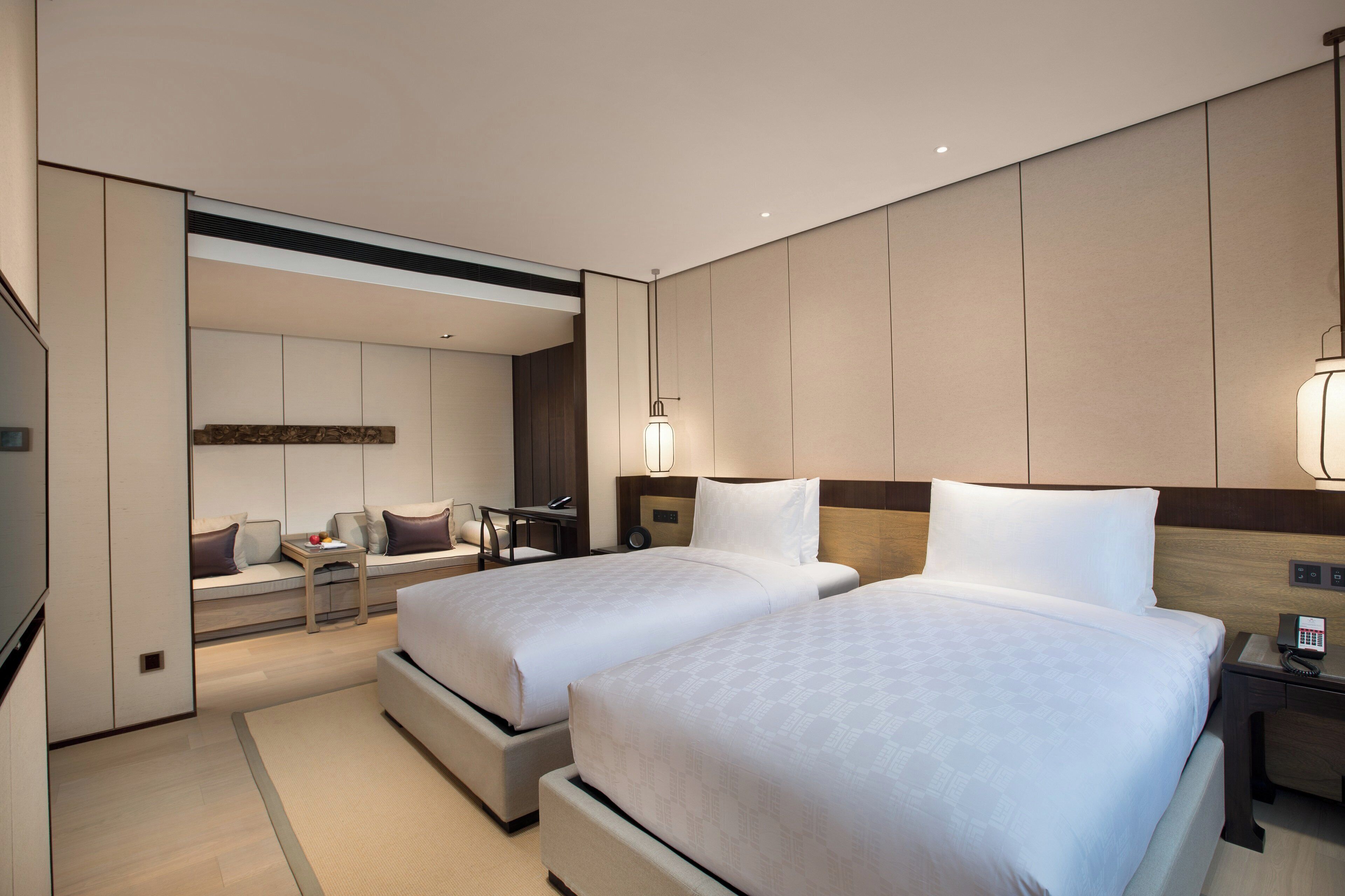 Una habitación de hotel moderna con dos camas, un escritorio y una zona de estar.
