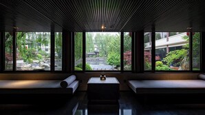 A modern interior with large windows, a central table, and seating areas. - HUALUXE Hotels and Resorts Xi'an Tanghua, an IHG hotel (Xi'an)