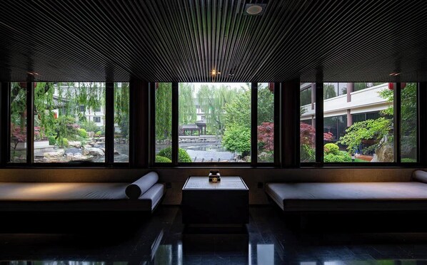 A modern interior with large windows, a central table, and seating areas. - HUALUXE Hotels and Resorts Xi'an Tanghua, an IHG hotel (Xi'an)