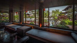 A modern interior with large windows, seating areas, and a view of a traditional courtyard. - HUALUXE Hotels and Resorts Xi'an Tanghua, an IHG hotel (Xi'an)