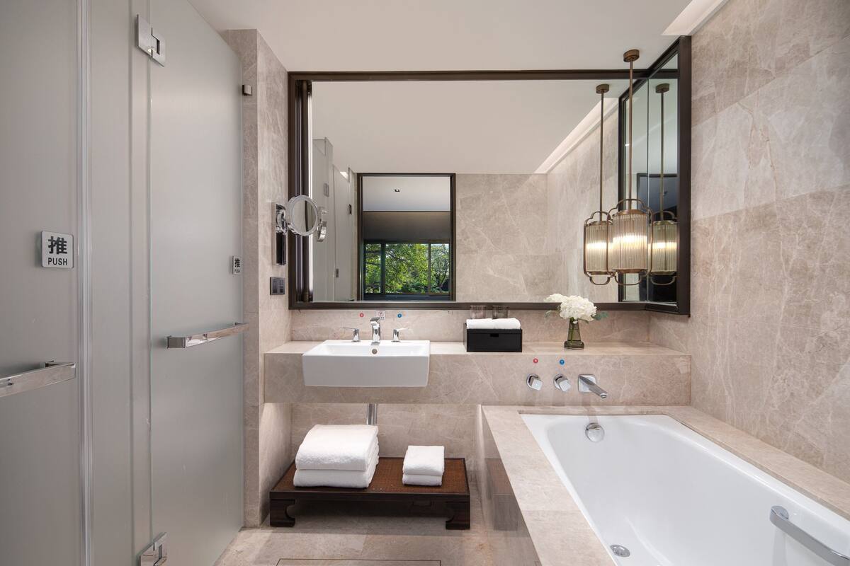 Un baño moderno con una bañera grande, un lavabo doble y un espejo sobre el mueble.