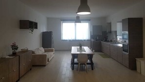Una cocina moderna con comedor, sofá y ventana que proporciona luz natural.