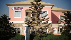 Un bâtiment rose sur lequel on peut lire l’inscription « HÔTEL TESCON ».