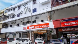 Un hôtel appelé « OYO Hotel New Sabah » avec une enseigne indiquant qu’il est possible d’y réserver une chambre.