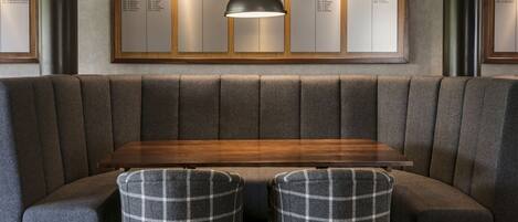 Un restaurante moderno con una mesa de madera y dos sillas a cuadros.