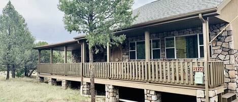 A two-story building with a stone facade and a wooden deck.