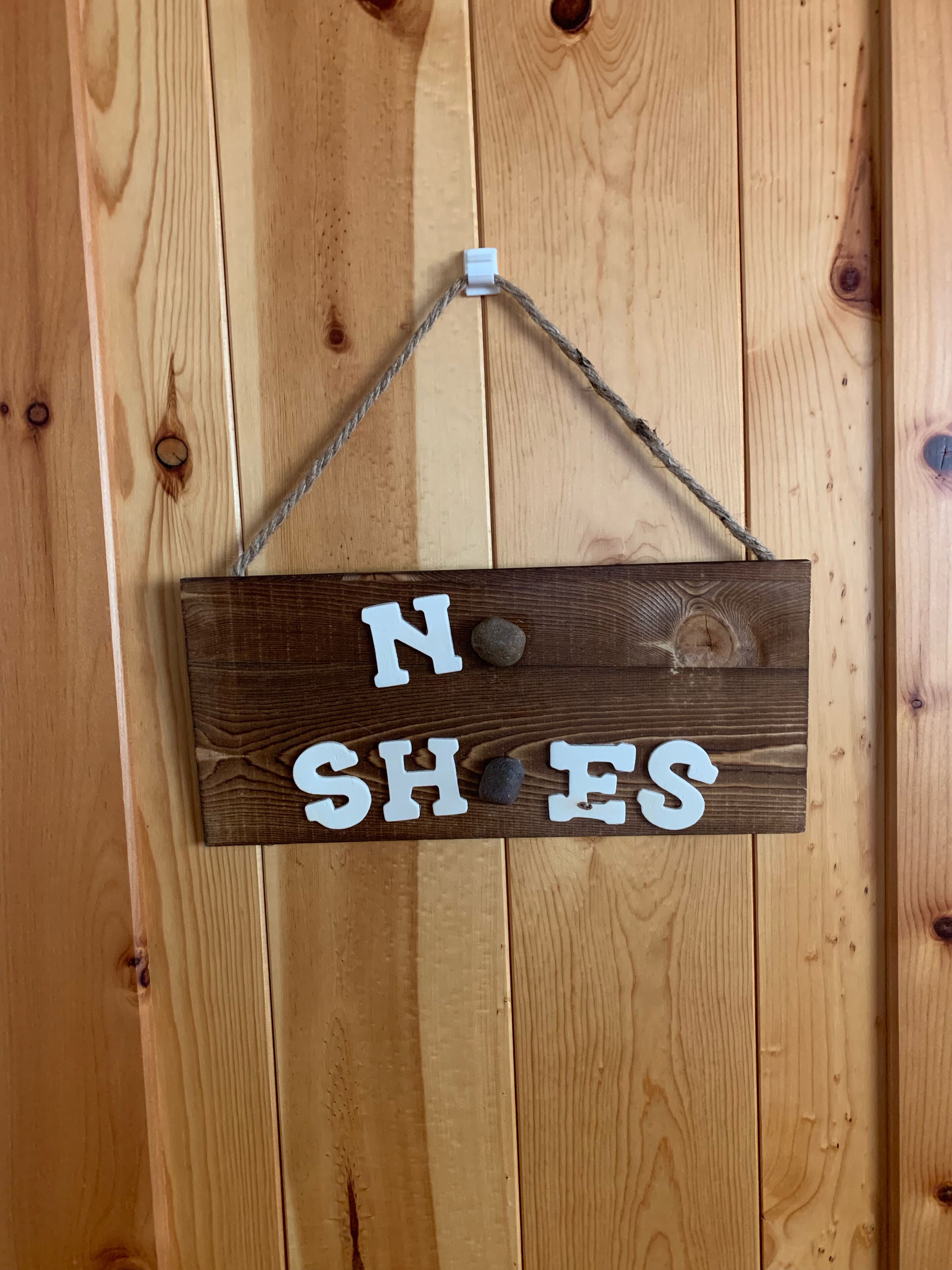Une pancarte en bois portant l’inscription « DÉFENSE D’Y ENTRER » est accrochée à un mur en bois.