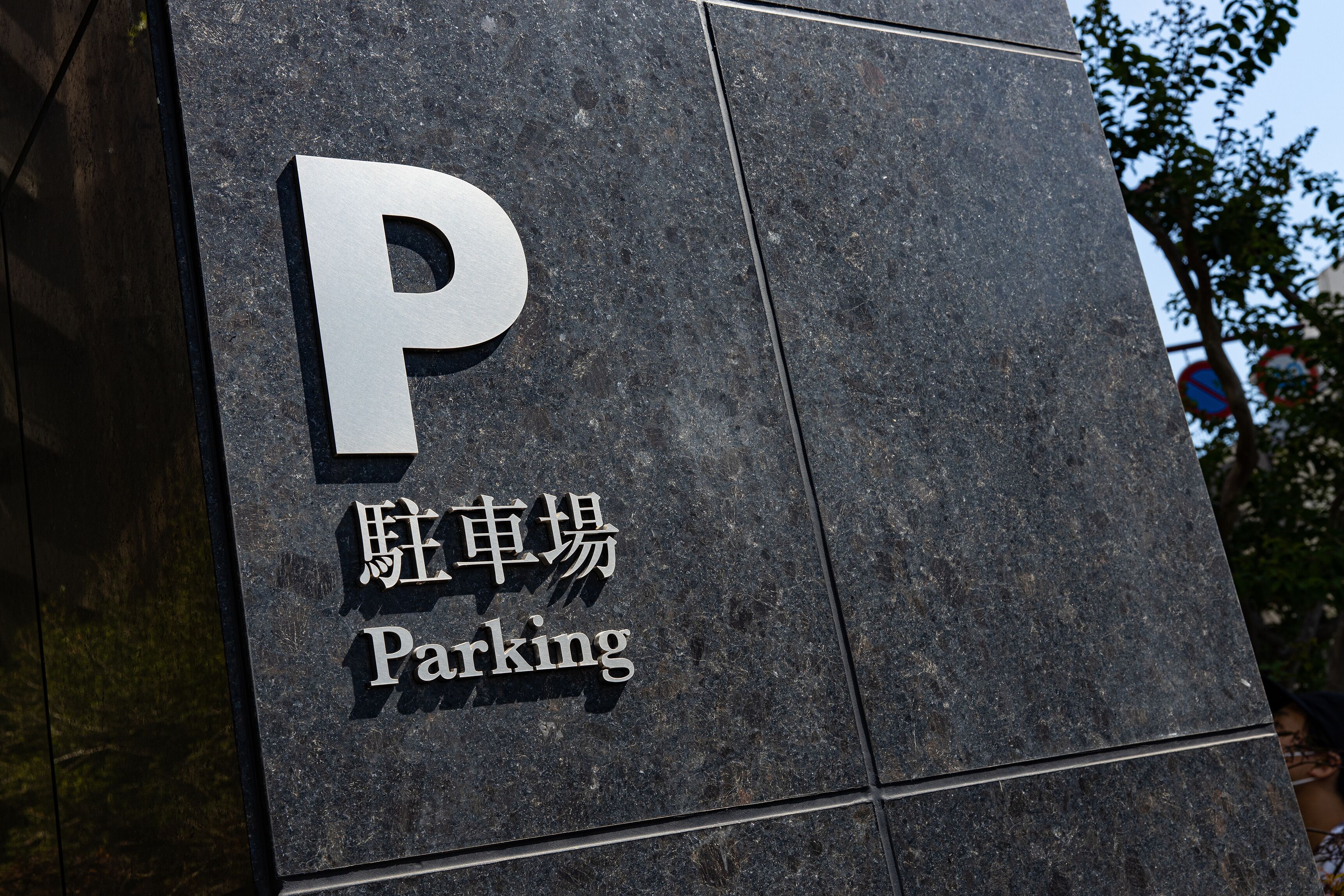 A parking sign with the letter 'P' and the words 'Parking' in both English and Chinese.