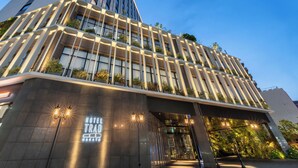 A modern hotel with a prominent entrance, large windows, and outdoor plants. - Hotel Trad Hakata (Fukuoka)