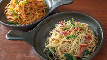 Two bowls of noodles with different toppings on a wooden table.