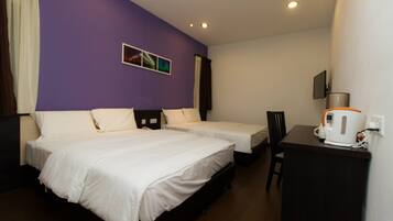 A hotel room with two beds, a desk, and a coffee maker.