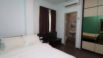 Una habitación de hotel con cama, escritorio, armario y baño.