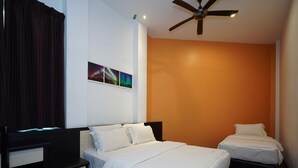 Habitación de hotel con dos camas, un ventilador de techo y una pared decorada con un cuadro de colores.