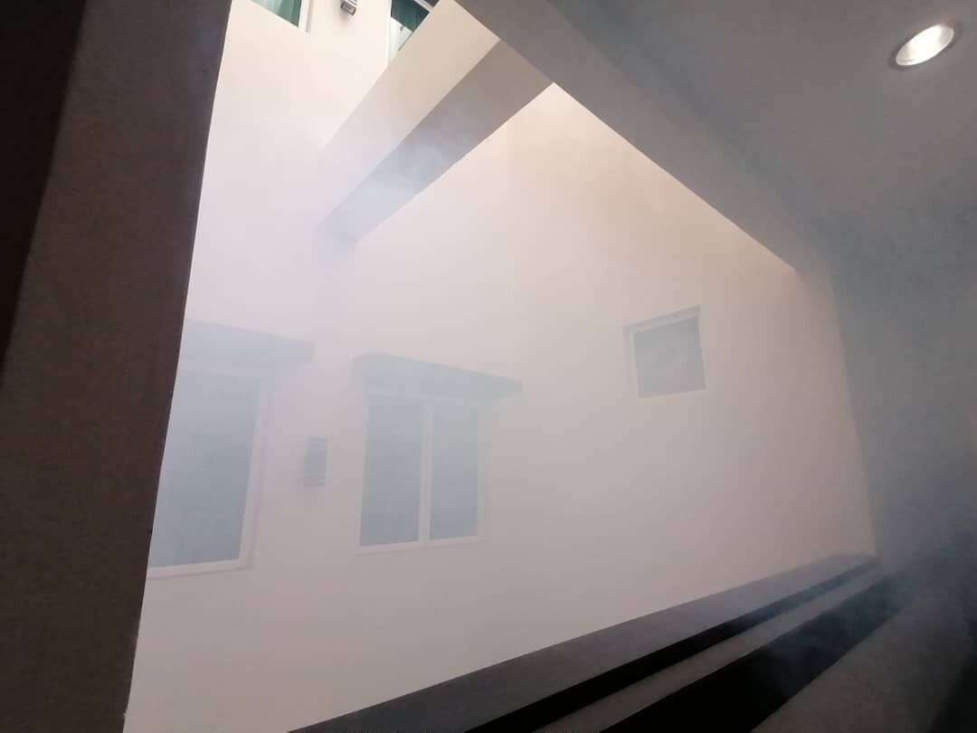 Un pasillo con una pared blanca y una ventana.