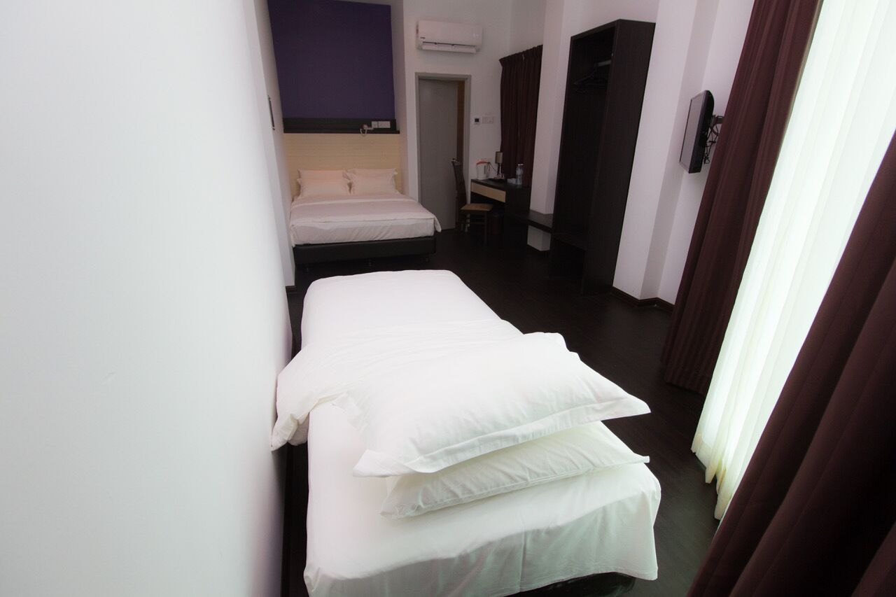 A hotel room with a bed, a desk, and a chair.