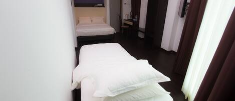A hotel room with a bed, a desk, and a chair.
