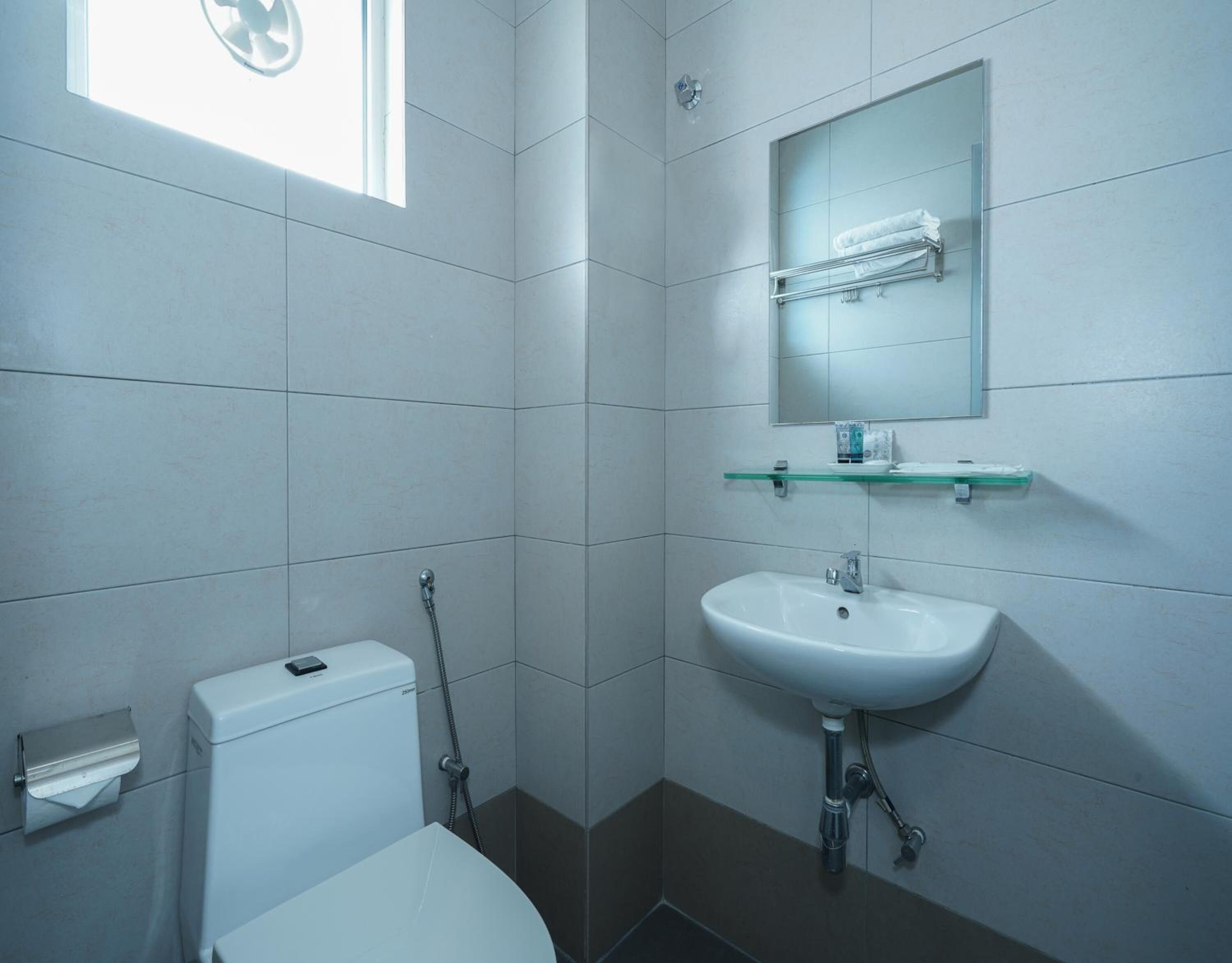 Une salle de bain moderne équipée de toilettes, d’un lavabo et d’une douche.
