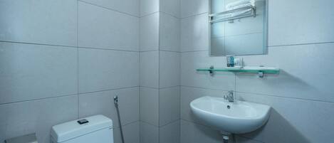 Un baño moderno con inodoro, lavabo y ducha.