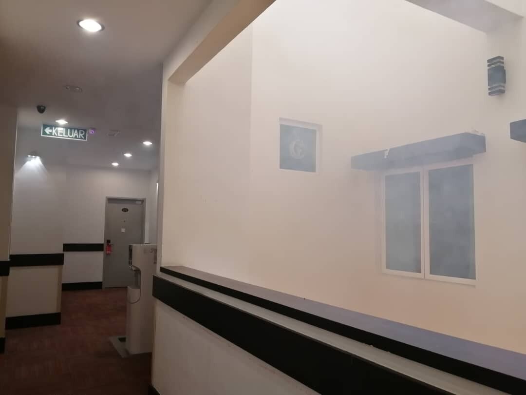 A hallway with a sign reading "KELUAR" and a door in the distance.