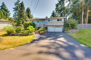 A two-story house with a garage, surrounded by a well-maintained lawn and trees. - 2 Mi to St Edward State Park: Ground-Level Studio (Kenmore)