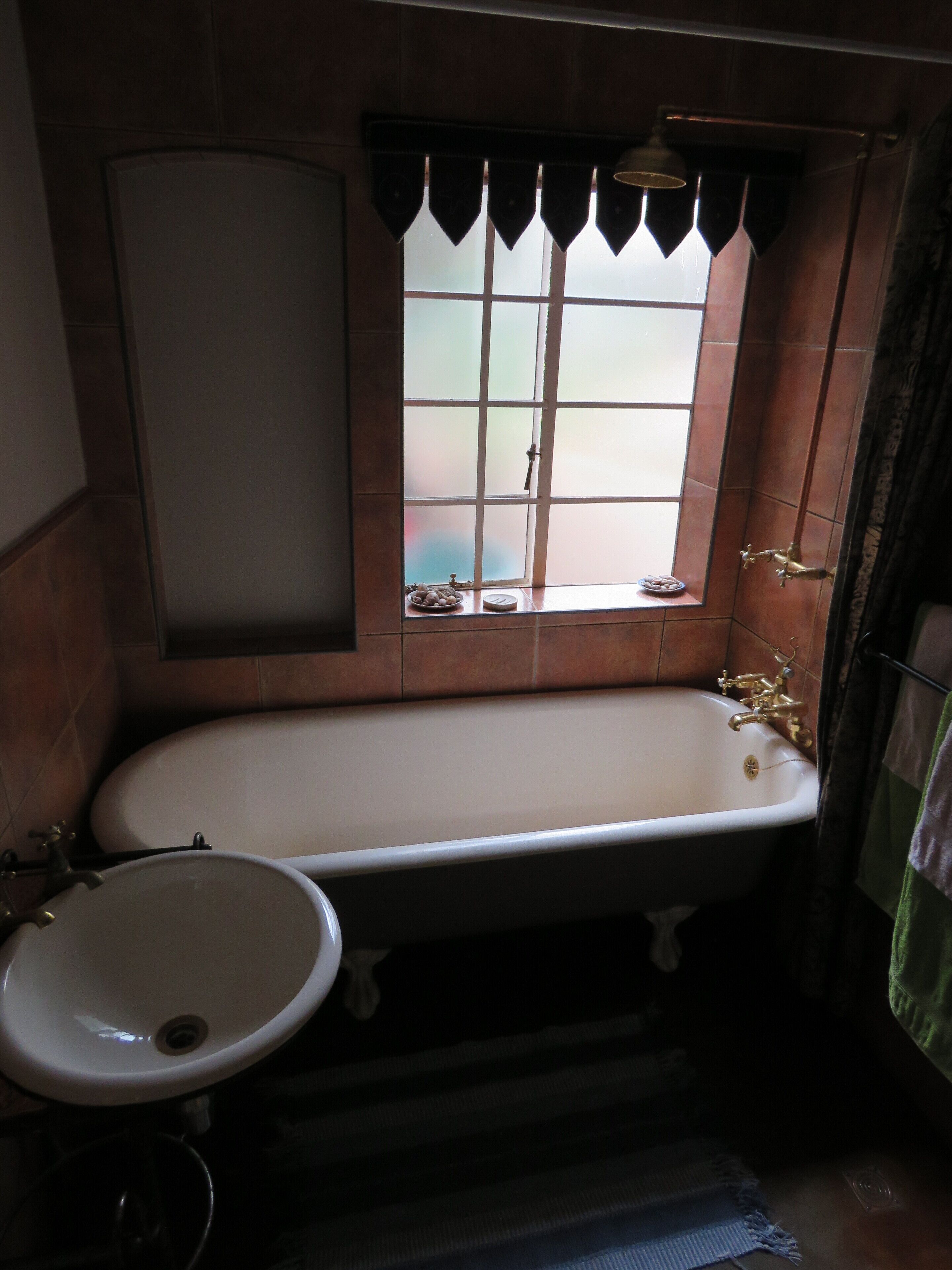 Une salle de bain avec une baignoire, un lavabo et une fenêtre donnant sur un beau paysage.