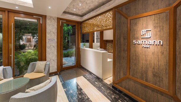 A reception area with a reception desk, seating area, and a view of the outdoors. - Samann Host (Hulhumalé)