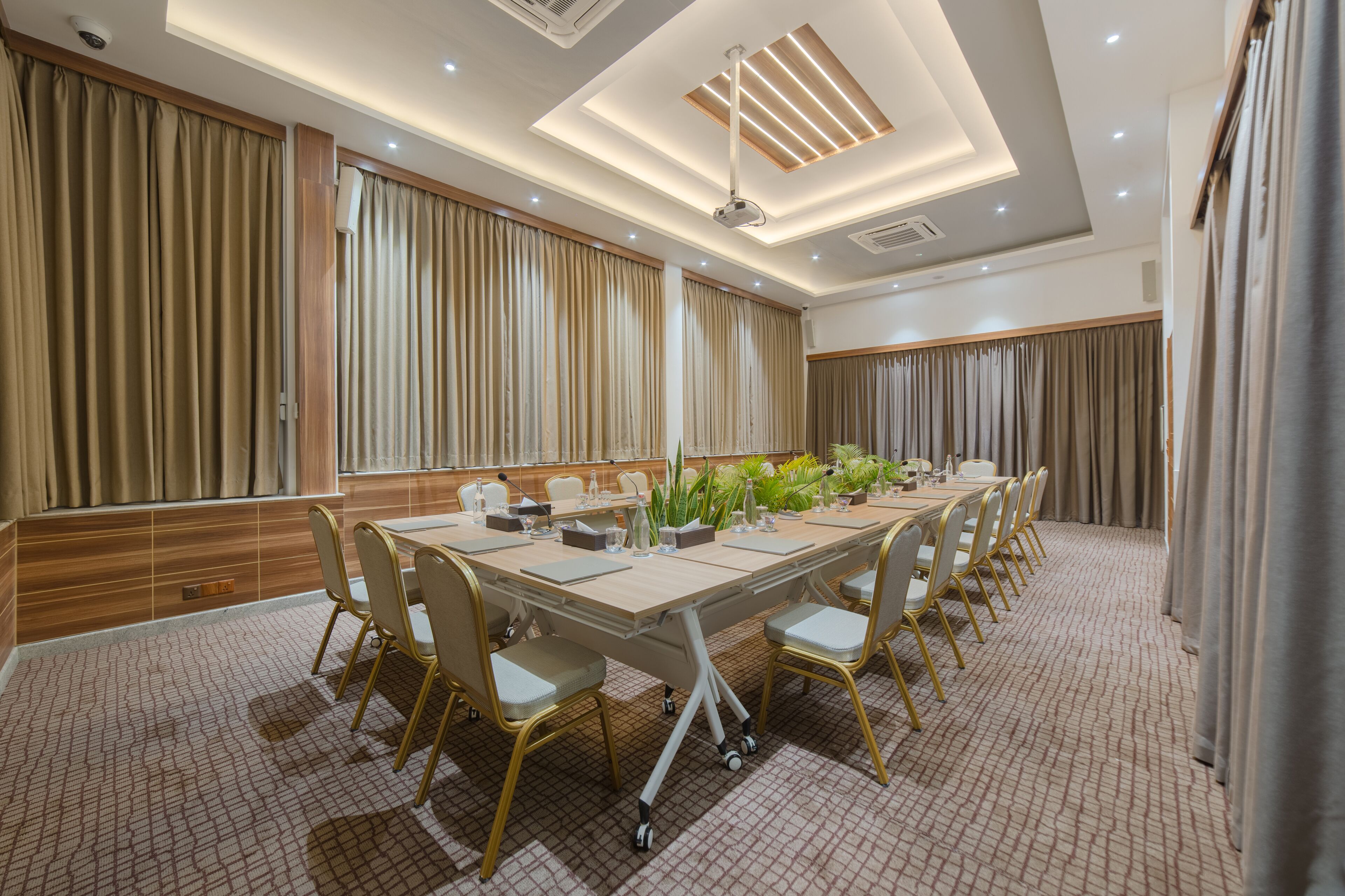 A conference room with a long table, chairs, and a projector.