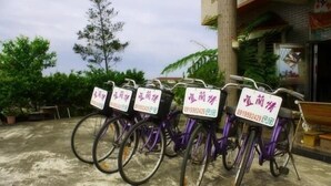 A row of purple bicycles with attached signs, parked on a concrete surface. - Yilan Feeling Homestay B&B (Wujie)